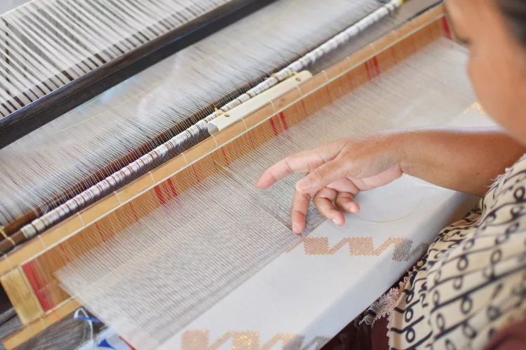 Imagen de mujer tejiendo tela a mano