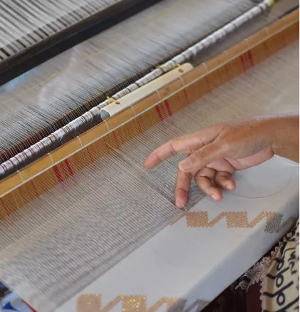 Mano de persona tejiendo telas a mano